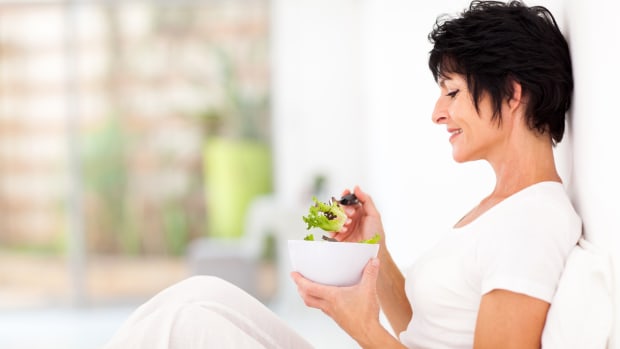 elegant middle aged woman eating salad